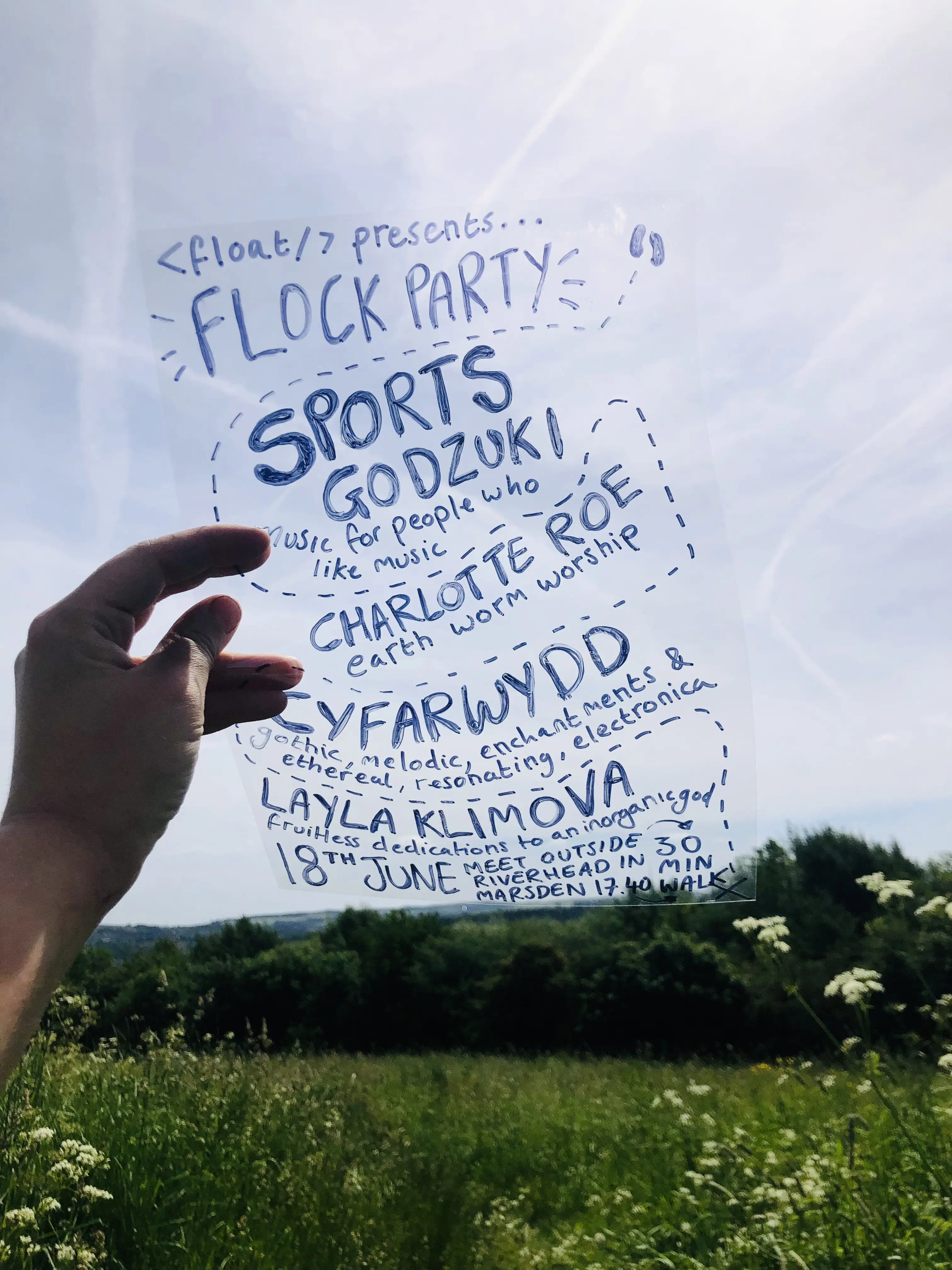 Gig poster containing the event details listed below written on a piece of acetate and held up against a blue sky.